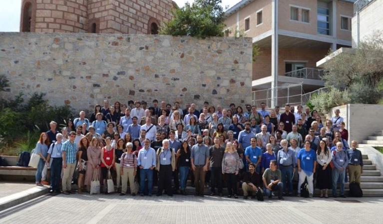 משתתפי הכינוס בכרתים על רקע של מבצר עתיק