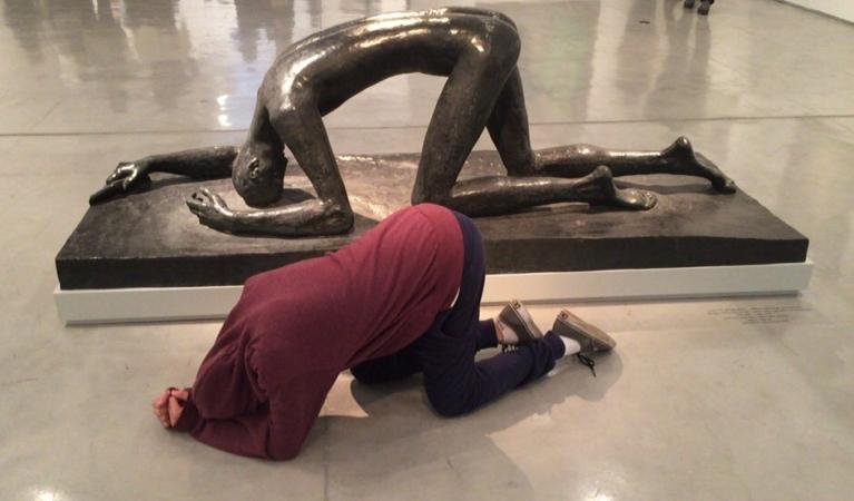 משתתפת בפעילות מחקה את התנוחה של יצירתו של אלברטו ג'אקומטי, "אישה מוונציה מס' 6" (1956), במוזיאון ישראל